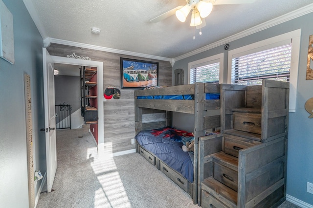 bedroom with baseboards, ceiling fan, carpet, a textured ceiling, and crown molding