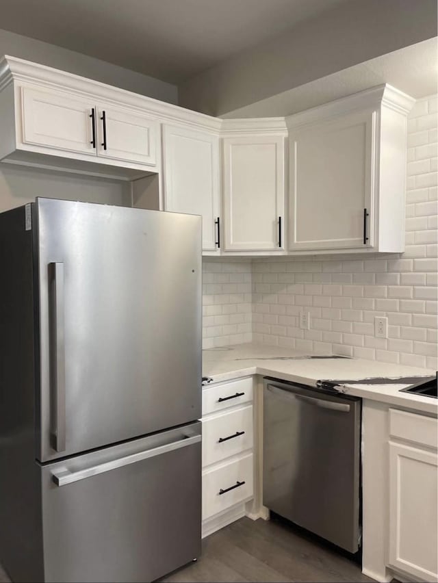 kitchen featuring white cabinets, decorative backsplash, dark hardwood / wood-style flooring, and stainless steel appliances