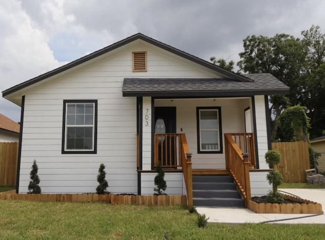 bungalow-style home with covered porch and a front yard