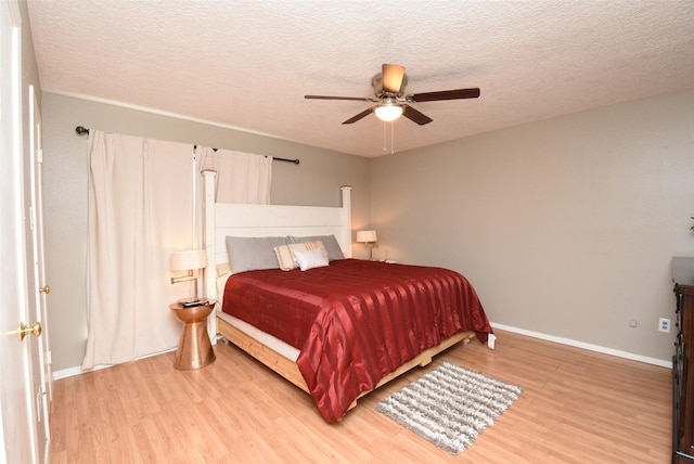 bedroom with a textured ceiling, hardwood / wood-style flooring, and ceiling fan