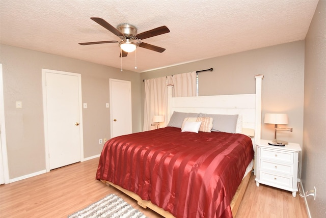 bedroom with ceiling fan, a textured ceiling, and light hardwood / wood-style flooring