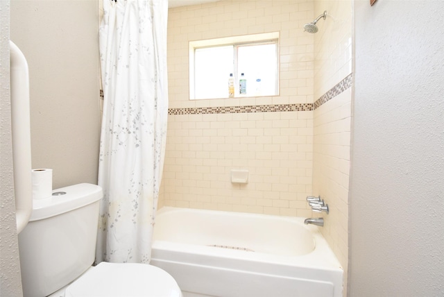 bathroom featuring shower / bath combination with curtain and toilet