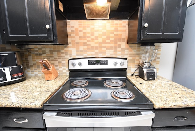 kitchen with backsplash, electric range, light stone counters, and wall chimney range hood