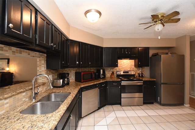 kitchen featuring backsplash, sink, ceiling fan, light tile patterned floors, and stainless steel appliances