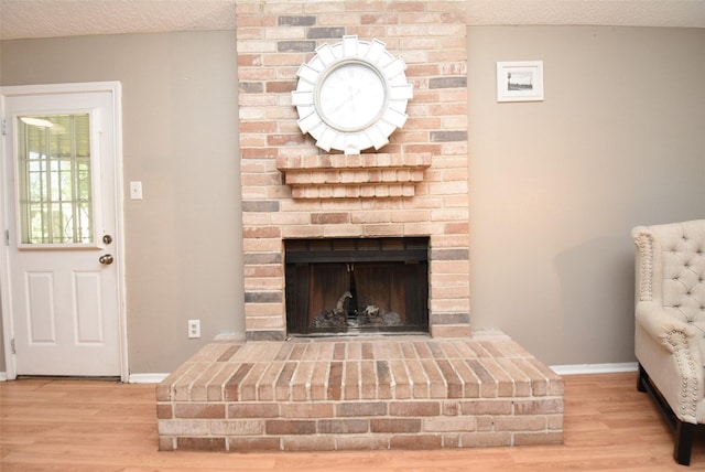 interior space with a fireplace, wood-type flooring, and a textured ceiling