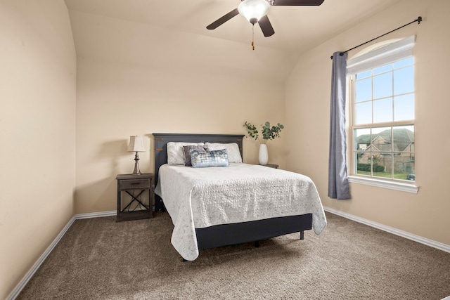 bedroom with multiple windows, ceiling fan, and dark carpet