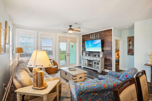 living room featuring a wealth of natural light, dark hardwood / wood-style flooring, ceiling fan, and french doors