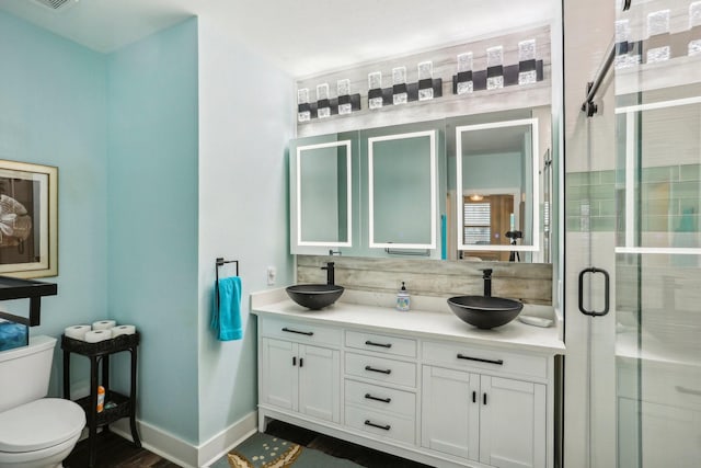 bathroom featuring hardwood / wood-style floors, vanity, toilet, and walk in shower