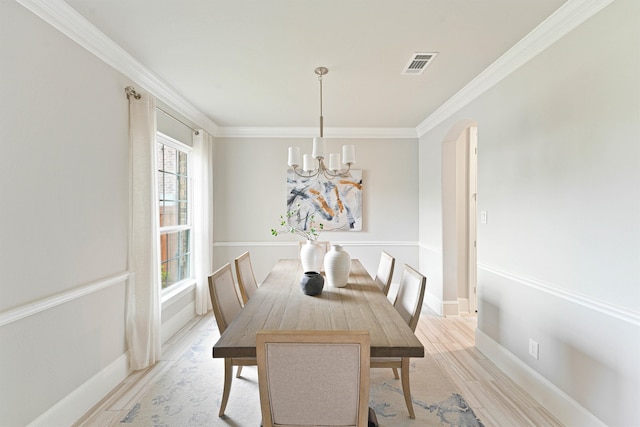 dining area with an inviting chandelier, light hardwood / wood-style flooring, a healthy amount of sunlight, and crown molding