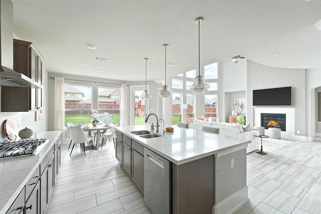 kitchen featuring sink, ceiling fan, an island with sink, dark brown cabinets, and stainless steel appliances