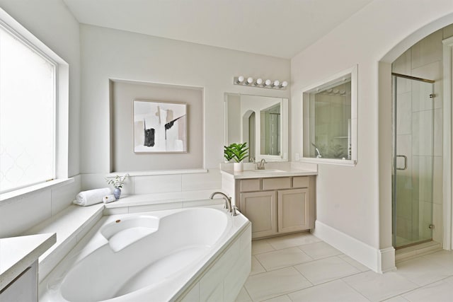 bathroom featuring tile patterned floors, vanity, and shower with separate bathtub