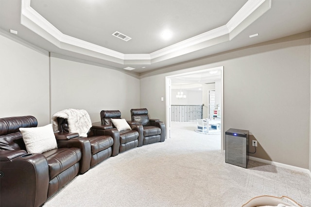 home theater with carpet flooring, a raised ceiling, and ornamental molding