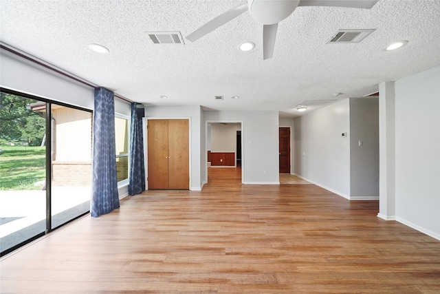 unfurnished room with ceiling fan, light hardwood / wood-style floors, and a textured ceiling