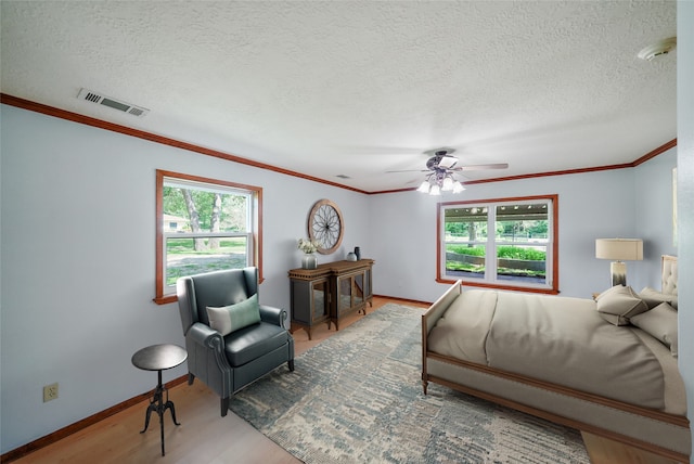 bedroom featuring a textured ceiling, hardwood / wood-style flooring, ceiling fan, and crown molding