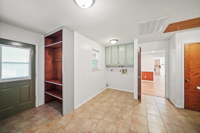 laundry room with cabinets, plenty of natural light, washer hookup, and a textured ceiling