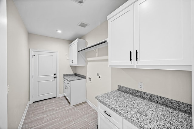 washroom with hookup for a washing machine, cabinets, and hookup for an electric dryer