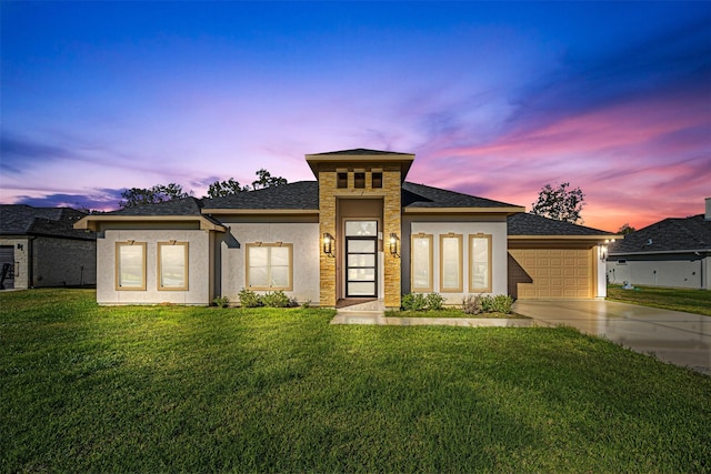 prairie-style house featuring a lawn and a garage