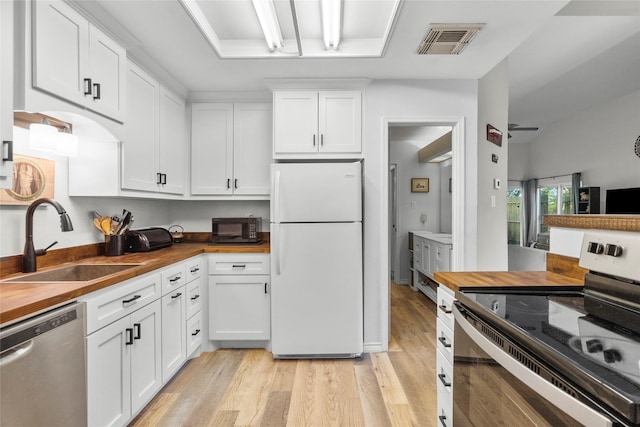 kitchen featuring electric range, sink, wood counters, stainless steel dishwasher, and white fridge