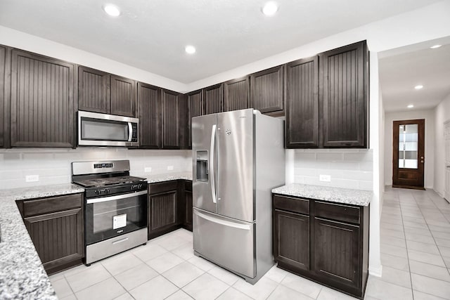 kitchen with decorative backsplash, light stone countertops, and stainless steel appliances