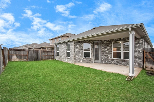 rear view of property with a yard and a patio