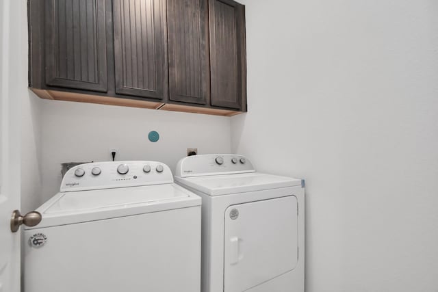 laundry room featuring washer and dryer and cabinets