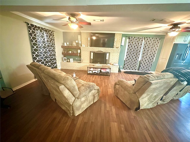 living room with crown molding, wood-type flooring, and a brick fireplace