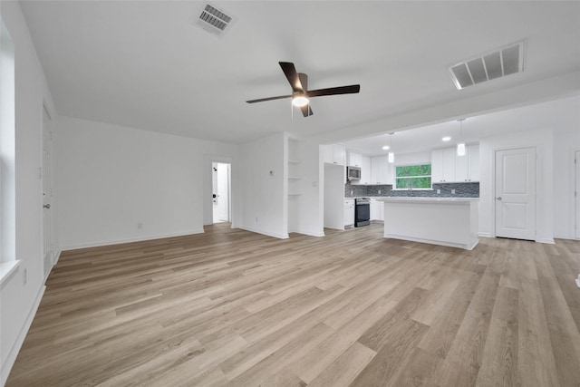 unfurnished living room with ceiling fan and light hardwood / wood-style floors