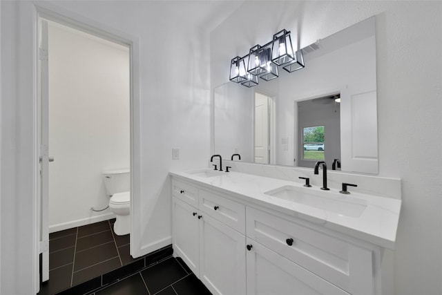 bathroom with tile patterned flooring, vanity, and toilet