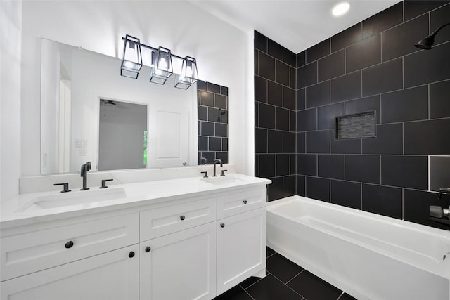 bathroom featuring tile patterned flooring, tiled shower / bath combo, and vanity