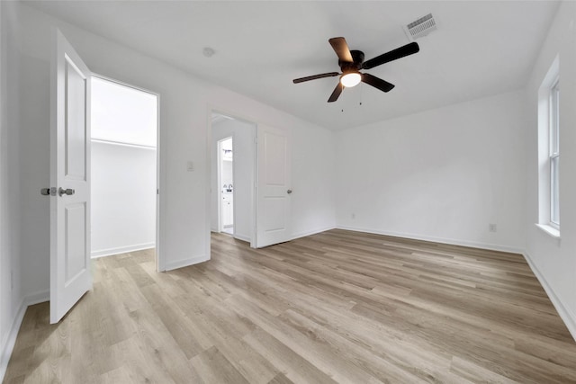 empty room with ceiling fan, light hardwood / wood-style floors, and plenty of natural light