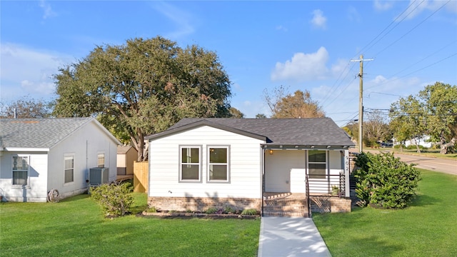 bungalow-style house with central AC unit, a porch, and a front lawn