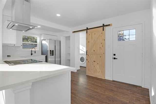 kitchen featuring stainless steel fridge, island range hood, a barn door, white cabinets, and dark hardwood / wood-style floors