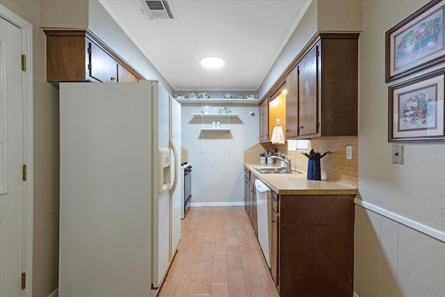 kitchen featuring sink, white appliances, and light wood-type flooring