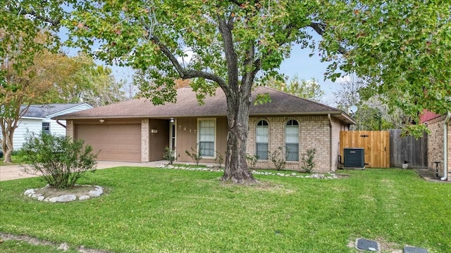 ranch-style home with cooling unit, a garage, and a front lawn