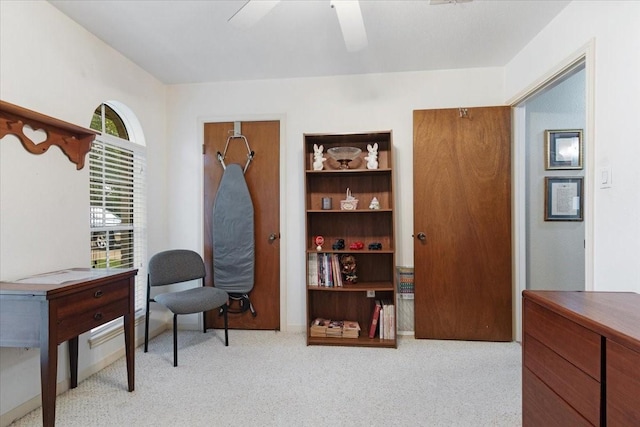 living area with light colored carpet and ceiling fan