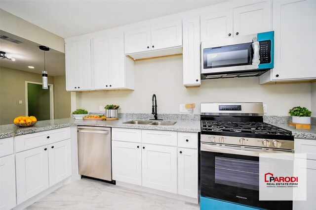 kitchen with light stone counters, white cabinetry, sink, and appliances with stainless steel finishes