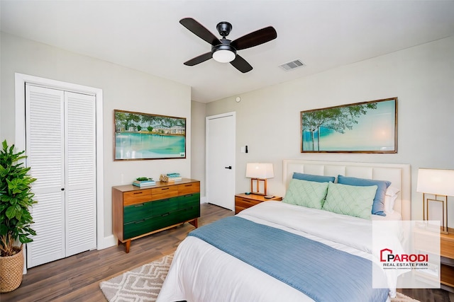 bedroom with ceiling fan, dark wood-type flooring, and a closet