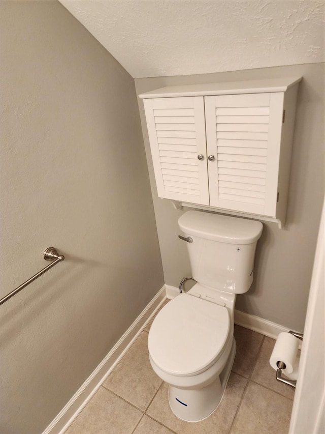 bathroom featuring tile patterned floors, toilet, and a textured ceiling