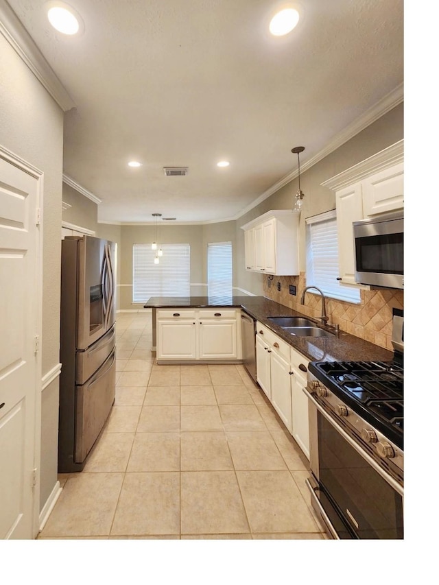 kitchen with kitchen peninsula, hanging light fixtures, stainless steel appliances, and sink