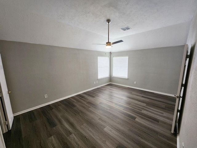 unfurnished room with a textured ceiling, dark hardwood / wood-style flooring, vaulted ceiling, and ceiling fan