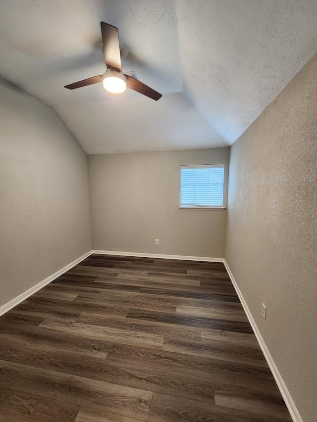 additional living space with ceiling fan, lofted ceiling, and dark wood-type flooring