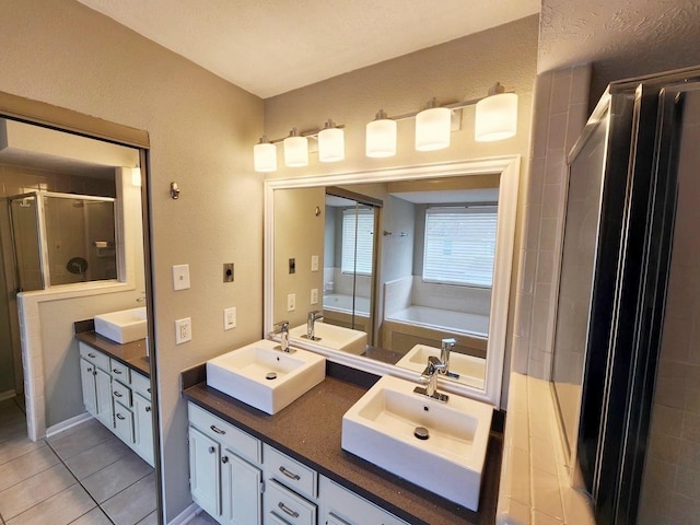 bathroom featuring tile patterned flooring, vanity, and separate shower and tub