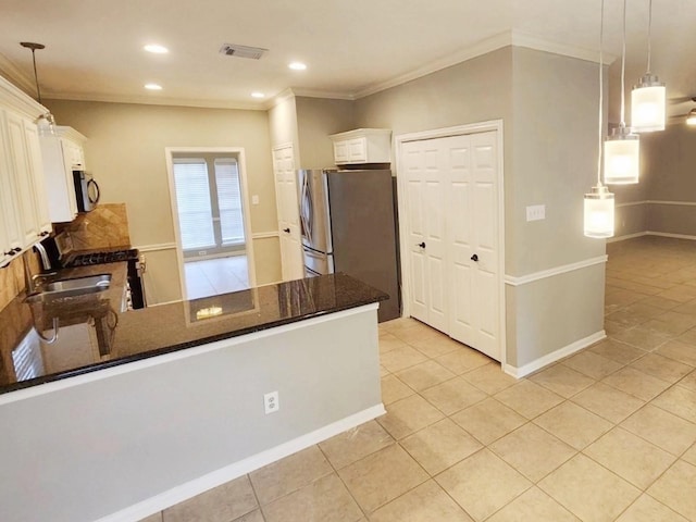 kitchen featuring kitchen peninsula, pendant lighting, stainless steel appliances, and white cabinetry