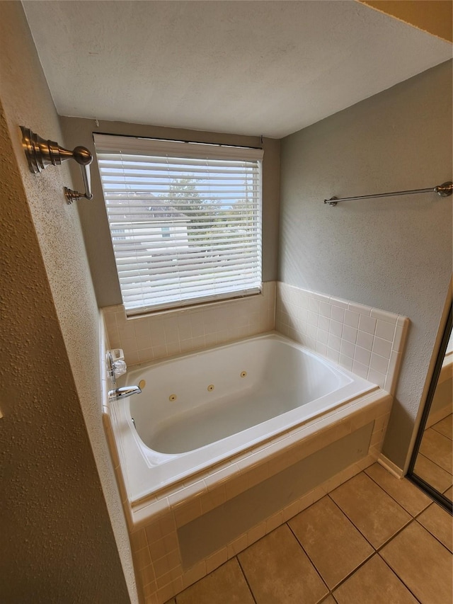 bathroom with tile patterned flooring, a textured ceiling, and tiled tub