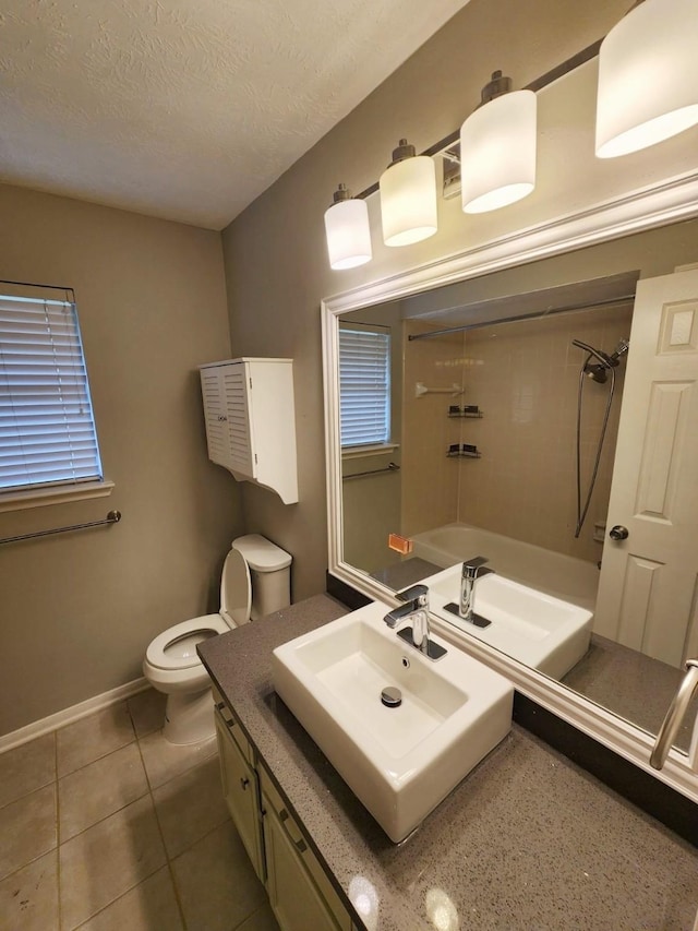 full bathroom with vanity, tile patterned floors, tiled shower / bath, toilet, and a textured ceiling