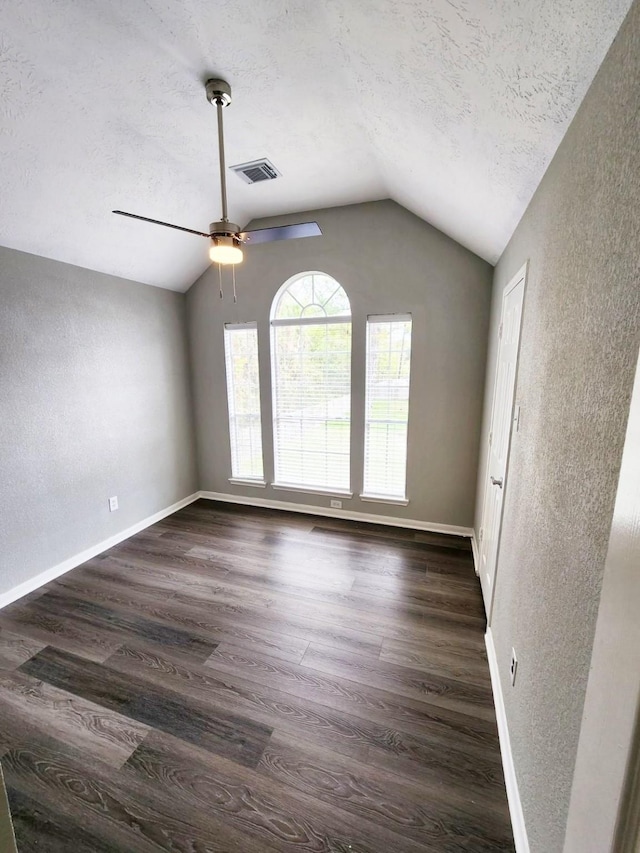 spare room featuring a textured ceiling, ceiling fan, dark hardwood / wood-style flooring, and vaulted ceiling