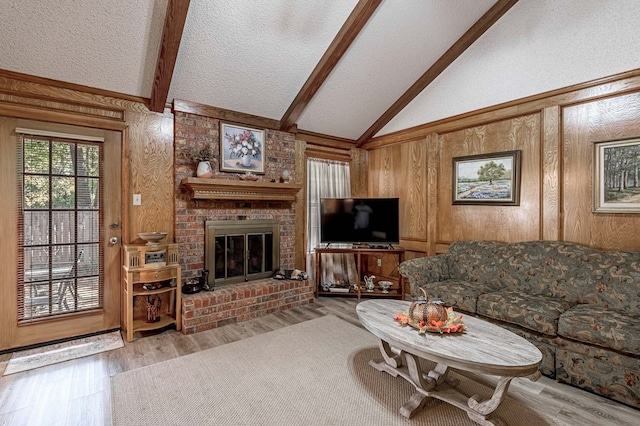 living room featuring light wood-type flooring, a brick fireplace, and wood walls