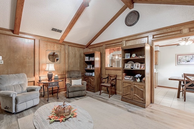 living room featuring hardwood / wood-style floors, lofted ceiling with beams, and a textured ceiling