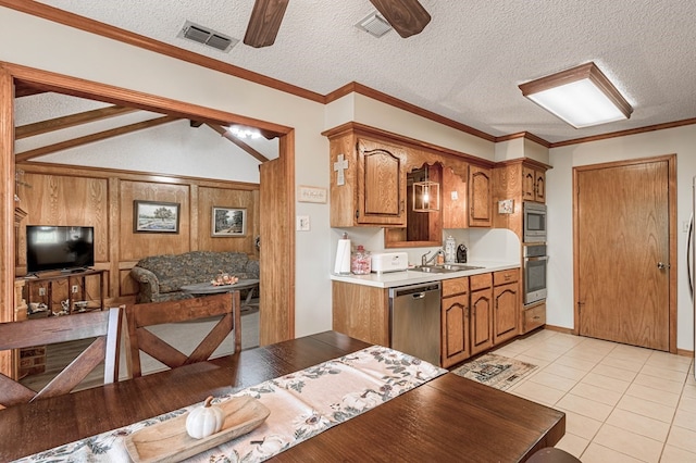 kitchen featuring appliances with stainless steel finishes, a textured ceiling, vaulted ceiling, and sink