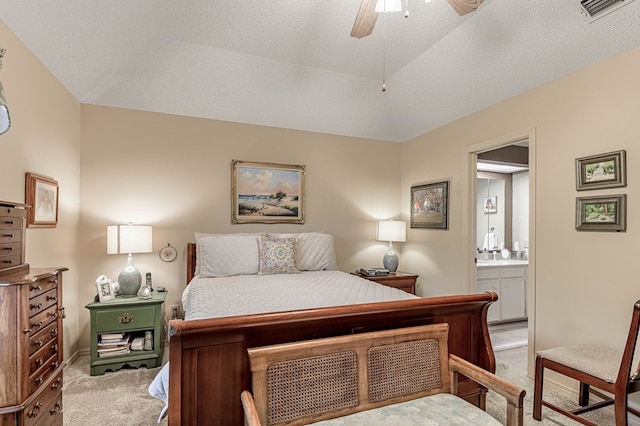 carpeted bedroom with ceiling fan, ensuite bathroom, and a textured ceiling